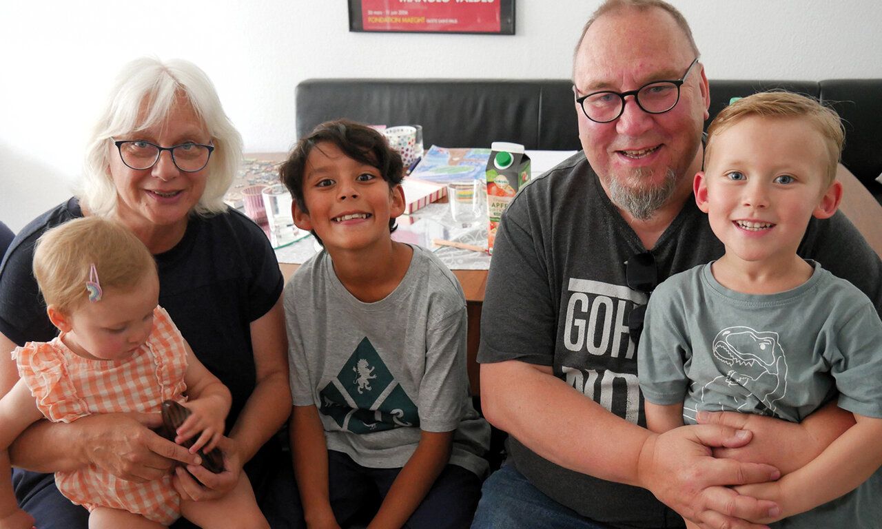 Gruppenbild: Oma und Opa mit drei Enkeln, im Hintergrund Tisch und eine Sitzbank