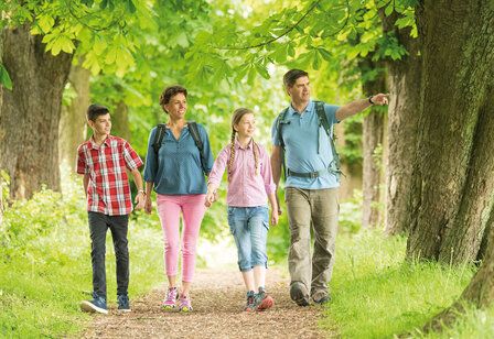 Eine Familie läuft auf einem Pfad, gesäumt von Kastanien