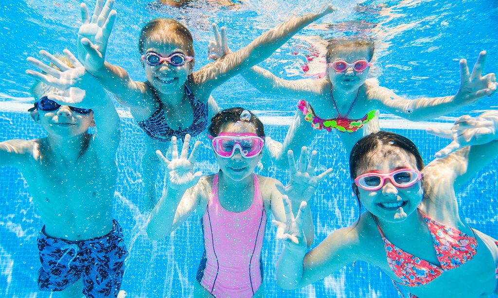 Fünf Kinder unter Wasser beim Schwimmenlernen