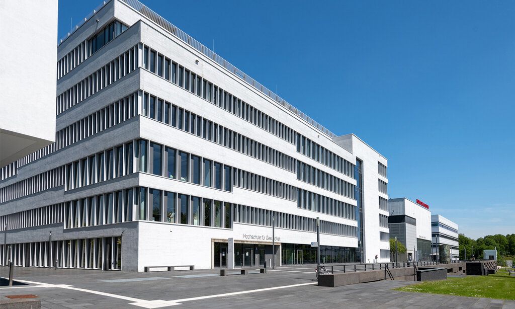 Gebäudekomplex von außen bei schönem Wetter, blauer Himmel