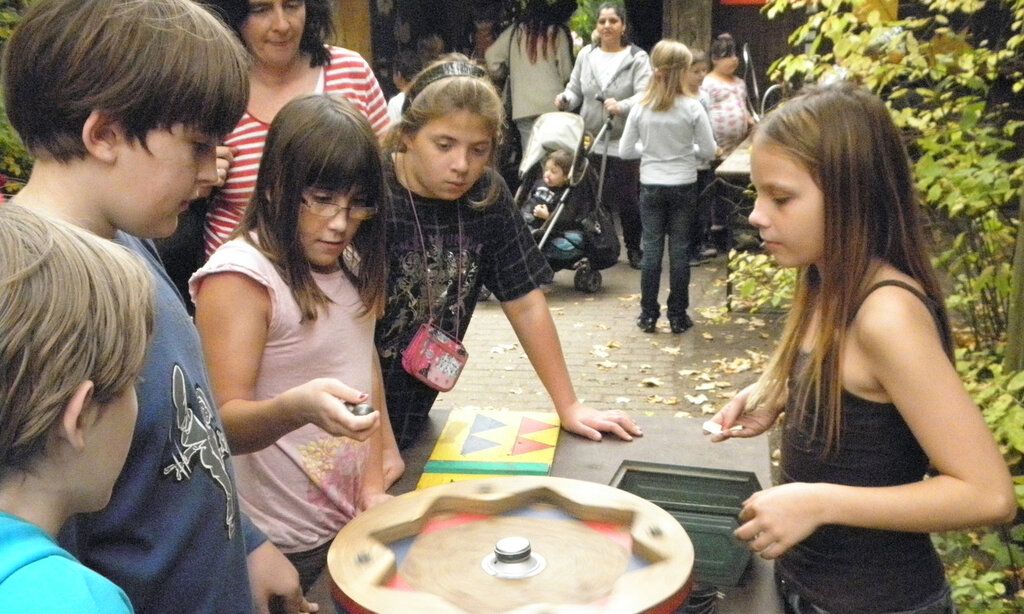 Kinder spielen eine Art Roulette auf dem Abenteuerspielplatz Eller