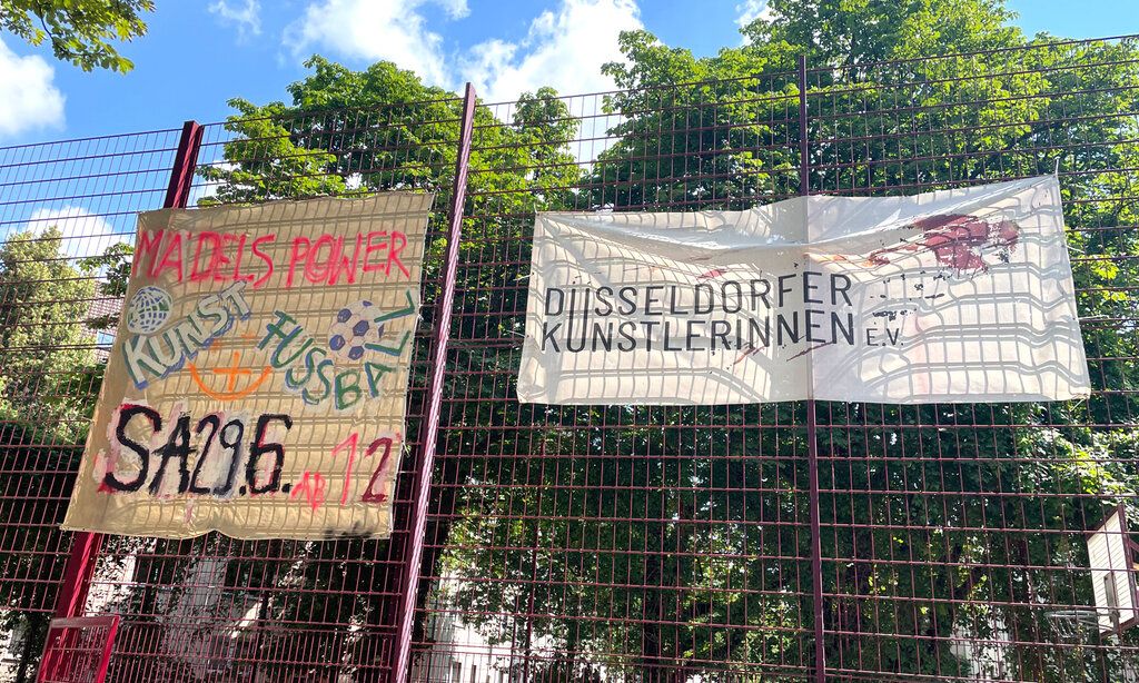 Banner hängen am Gitter des Bolzplatzes am Spichernplatz