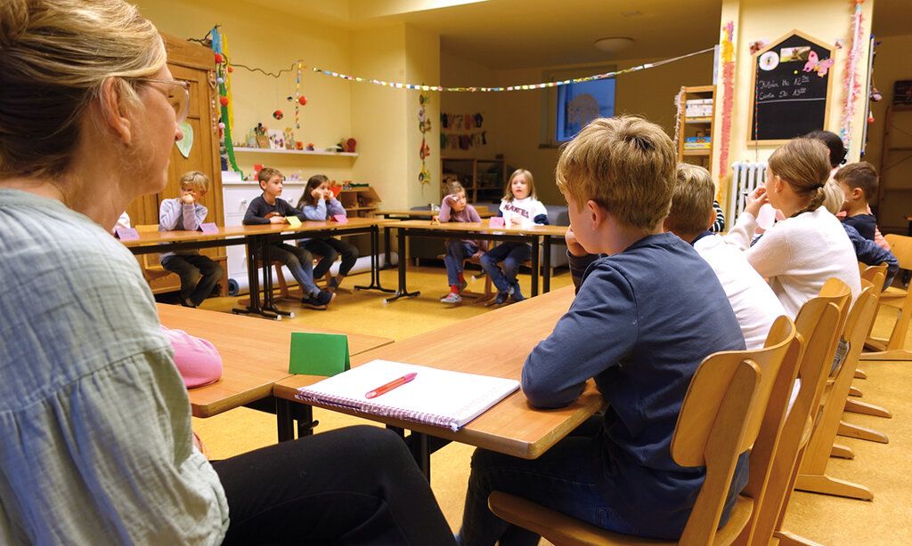 das Schülerparlament der Grundschule sitzt in einem Klassenraum zusammen