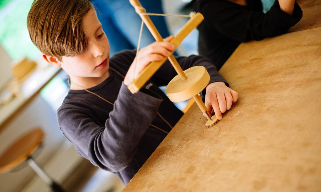 junge bastelt ein Amulette aus Holz