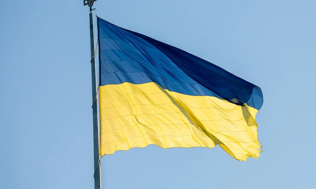 Ukrainische Flagge weht im Wind vor blauem Himmel