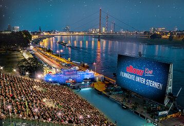 alltours Open Air Kino, bei Nacht, im Hintergrund Rhein, Oberkassler Brücke, Düsseldorfer Skyline
