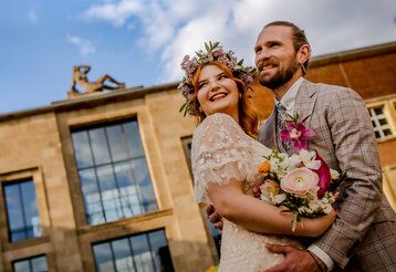 Hochzeitspaar häöt sich in den Armen, im Hintergrund  Kunstpalast Ehrenhof