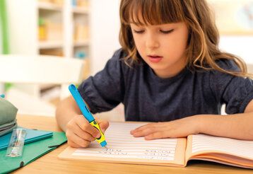 Kind schreibt mit einem Griffix-Füller von Pelikan in ein Schreibheft
