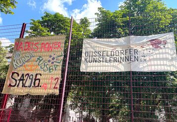 Banner hängen am Gitter des Bolzplatzes am Spichernplatz