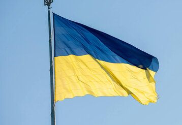 Ukrainische Flagge weht im Wind vor blauem Himmel